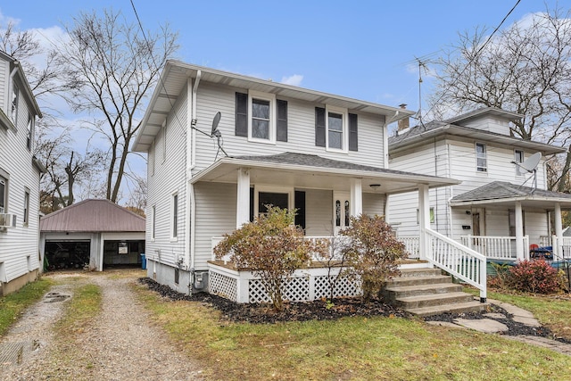 view of front facade with a garage, a porch, and an outbuilding