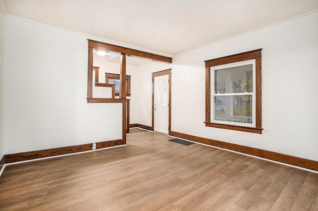 spare room with crown molding and wood-type flooring