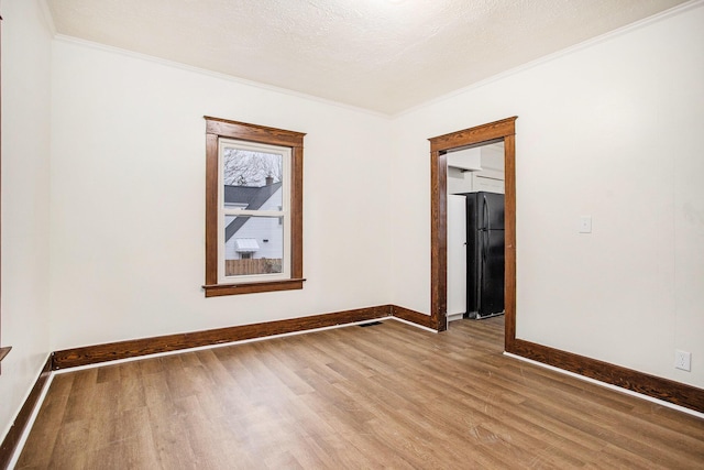 unfurnished room with hardwood / wood-style flooring, crown molding, and a textured ceiling