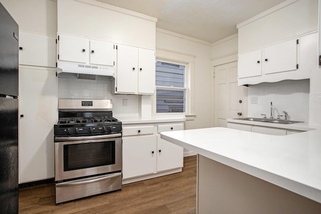 kitchen with dark wood-type flooring, stainless steel range with gas stovetop, sink, and white cabinets