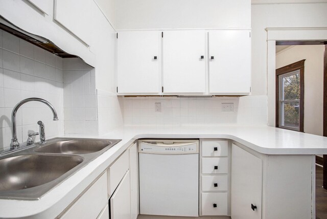 kitchen featuring sink, dishwasher, tasteful backsplash, white cabinets, and kitchen peninsula