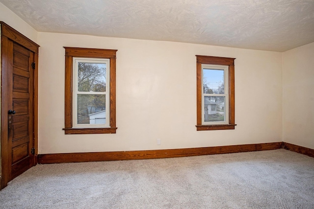 empty room with carpet and a textured ceiling