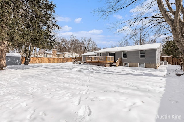 snow covered house with a wooden deck