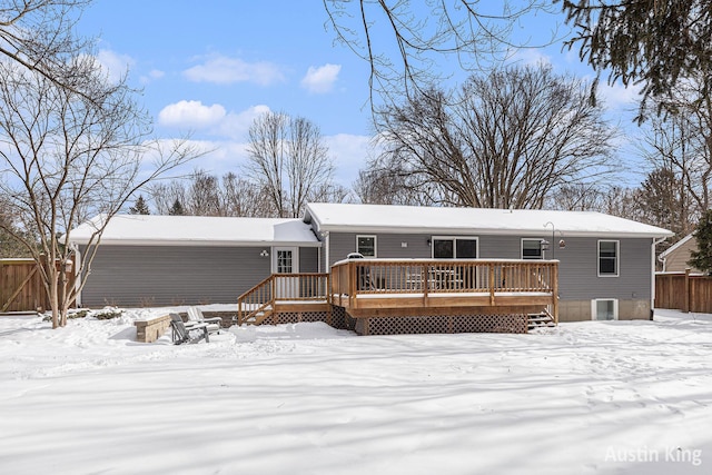 snow covered back of property featuring a deck