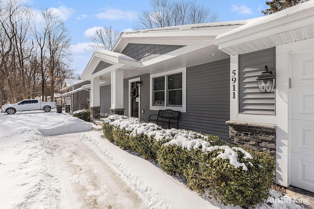 snow covered property featuring covered porch