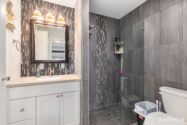 bathroom with toilet, tile walls, a tile shower, tasteful backsplash, and vanity