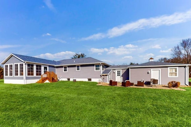 rear view of house with a yard, a patio, and a sunroom