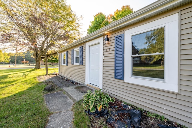 view of exterior entry with a lawn