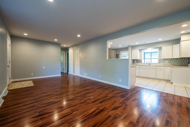 unfurnished living room featuring sink and light hardwood / wood-style floors