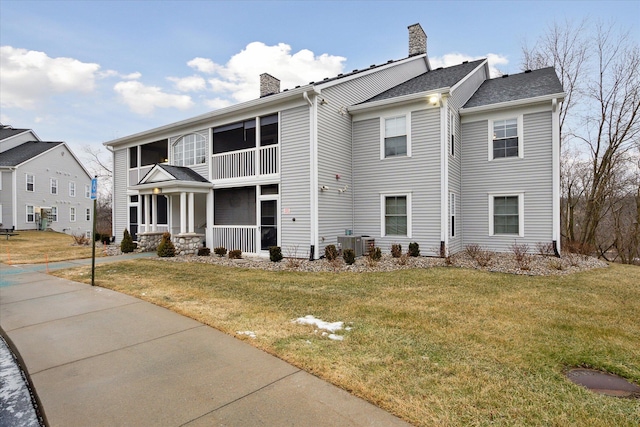 view of front of home featuring central AC, covered porch, and a front lawn