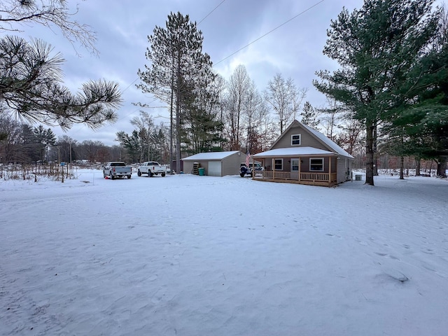 exterior space with a garage, an outbuilding, and a porch