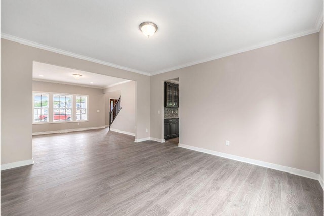 empty room featuring hardwood / wood-style flooring and ornamental molding