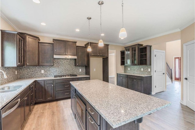 kitchen featuring sink, decorative light fixtures, a center island, stainless steel dishwasher, and light hardwood / wood-style floors