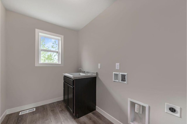 laundry area with sink, electric dryer hookup, hookup for a washing machine, cabinets, and dark hardwood / wood-style floors