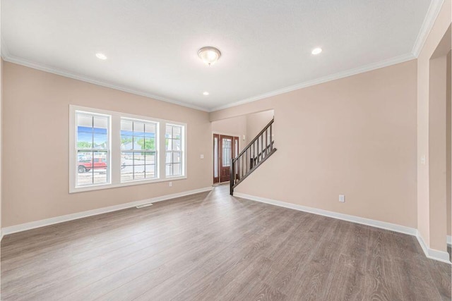 spare room featuring crown molding and light hardwood / wood-style flooring