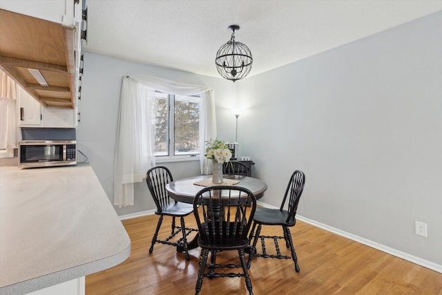 dining room with an inviting chandelier and light wood-type flooring