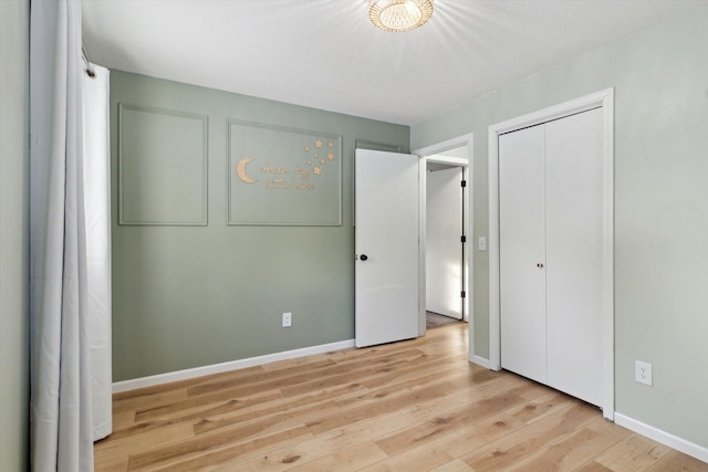 unfurnished bedroom with light hardwood / wood-style flooring and a closet