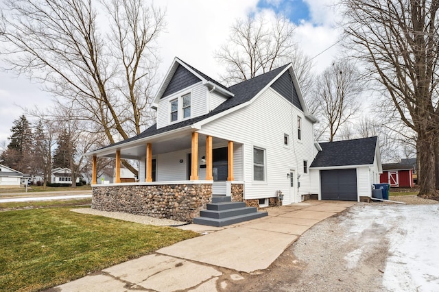 view of front of home with an outbuilding, a porch, a garage, and a front yard