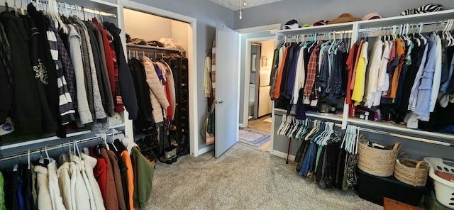 walk in closet featuring light carpet