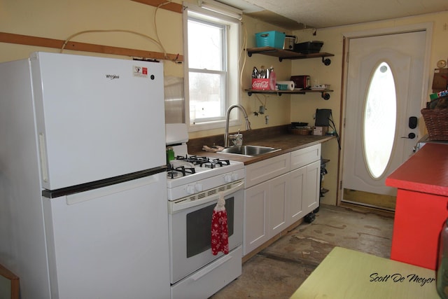 kitchen featuring sink, white cabinets, and white appliances