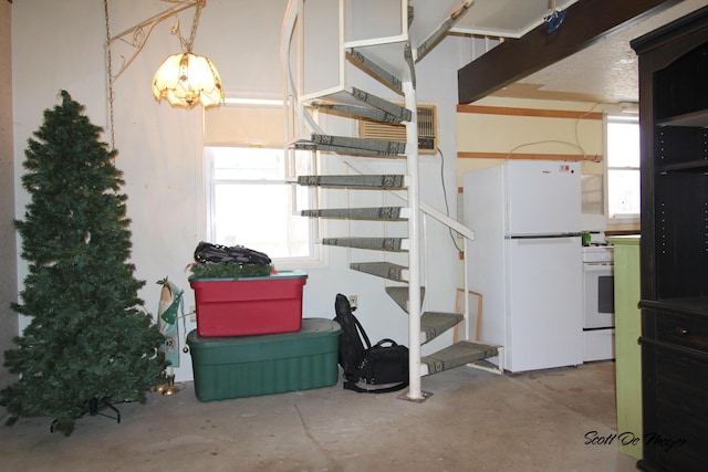 basement featuring white fridge and a wealth of natural light