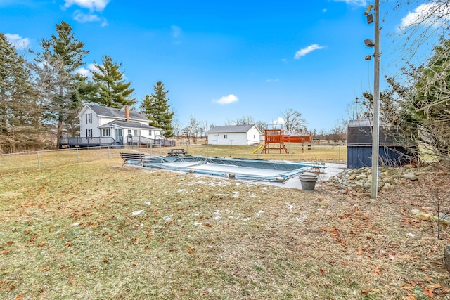 view of yard with a shed, a playground, and a covered pool