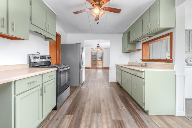 kitchen with green cabinetry, appliances with stainless steel finishes, and sink