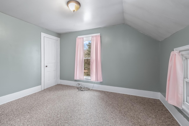 bonus room with vaulted ceiling and carpet floors