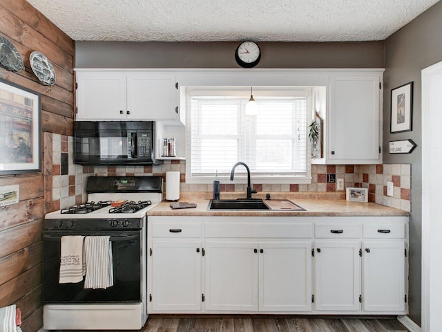 kitchen featuring white cabinetry, hanging light fixtures, sink, and range with gas cooktop