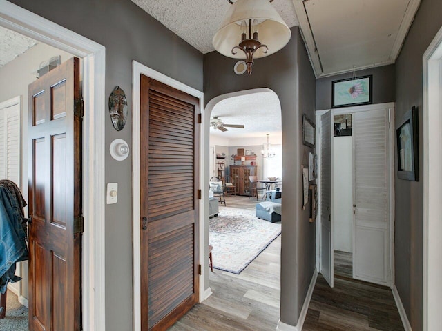 corridor featuring light hardwood / wood-style floors and a textured ceiling