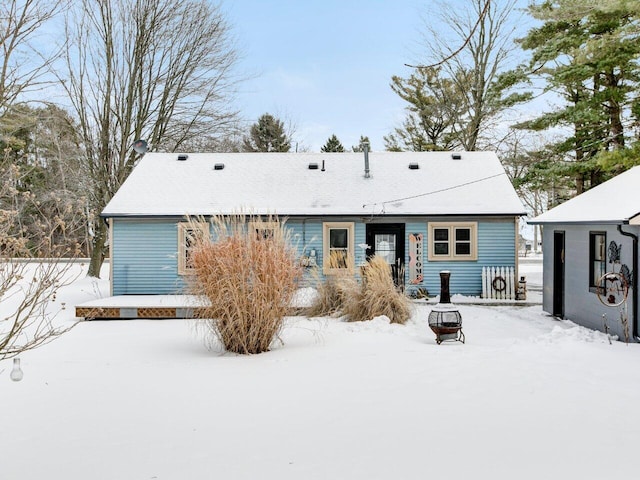 snow covered house featuring an outdoor fire pit