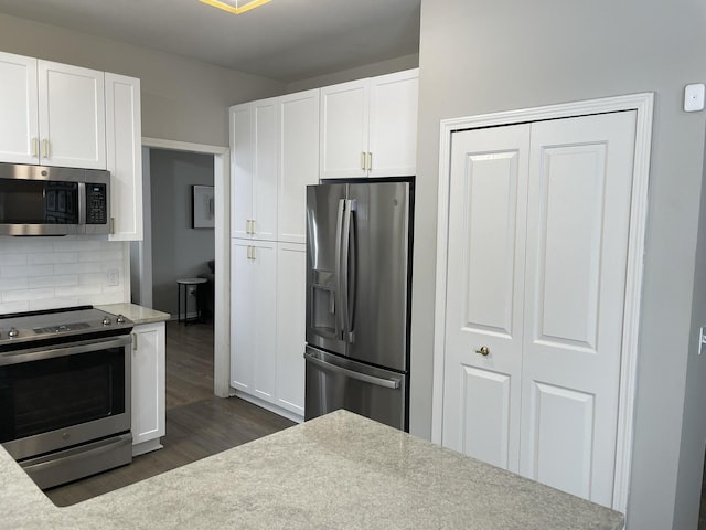 kitchen featuring white cabinets, stainless steel appliances, backsplash, and dark wood-type flooring