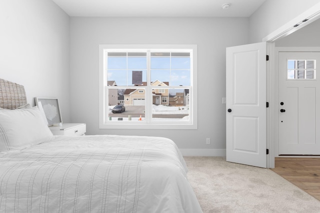 bedroom with multiple windows and light carpet