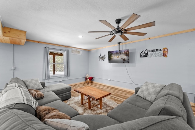 living room with hardwood / wood-style flooring, ceiling fan, and a textured ceiling