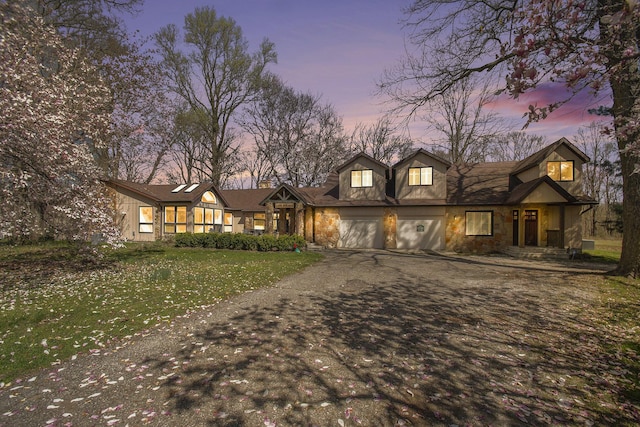 view of front of house with a garage, stone siding, aphalt driveway, and a front yard