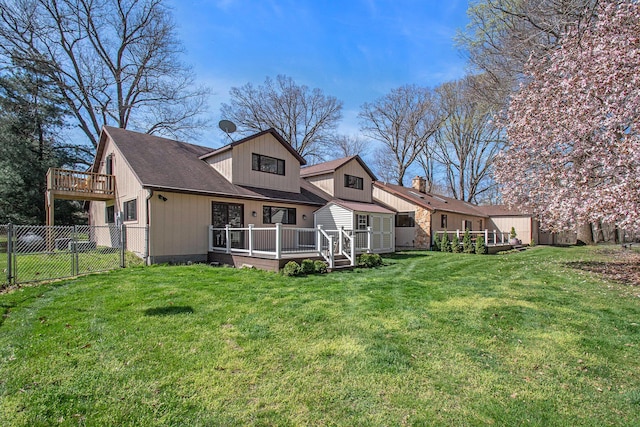 rear view of house with a fenced backyard, a gate, a deck, and a yard