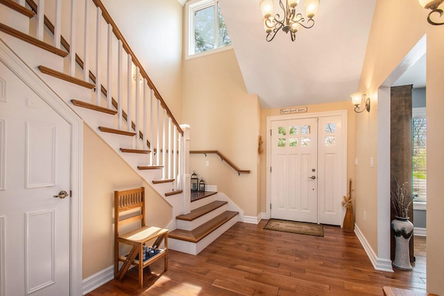 entryway with baseboards, a high ceiling, stairway, and hardwood / wood-style floors