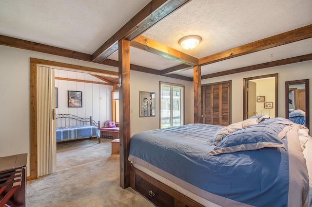 bedroom featuring light carpet, a textured ceiling, and beam ceiling