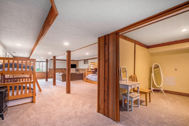 carpeted bedroom featuring recessed lighting, wainscoting, wooden walls, a textured ceiling, and baseboards
