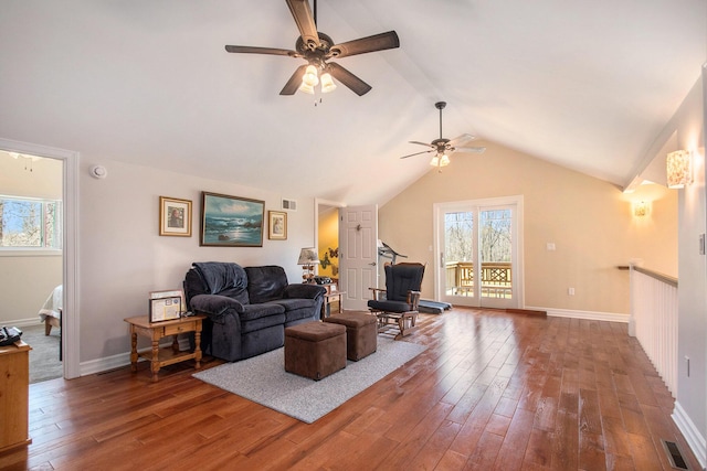 living room with lofted ceiling, wood finished floors, visible vents, and baseboards