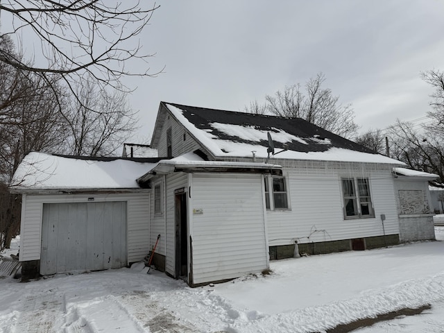 snow covered property featuring a garage