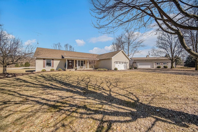 ranch-style house with covered porch, an attached garage, driveway, and a front lawn