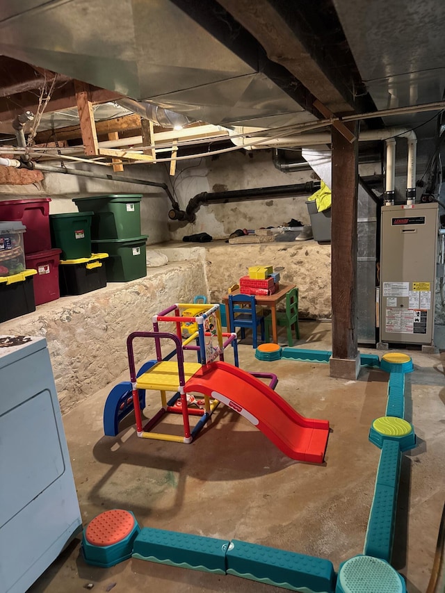 view of play area featuring heating unit and washer / clothes dryer