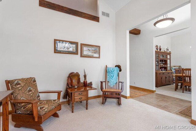 sitting room featuring light carpet and lofted ceiling