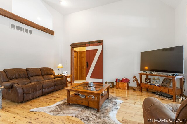 living room with hardwood / wood-style floors and high vaulted ceiling