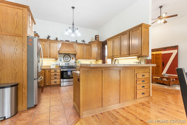 kitchen featuring appliances with stainless steel finishes, high vaulted ceiling, decorative light fixtures, custom exhaust hood, and kitchen peninsula