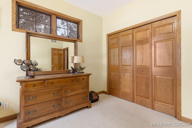 bedroom featuring light colored carpet and a closet