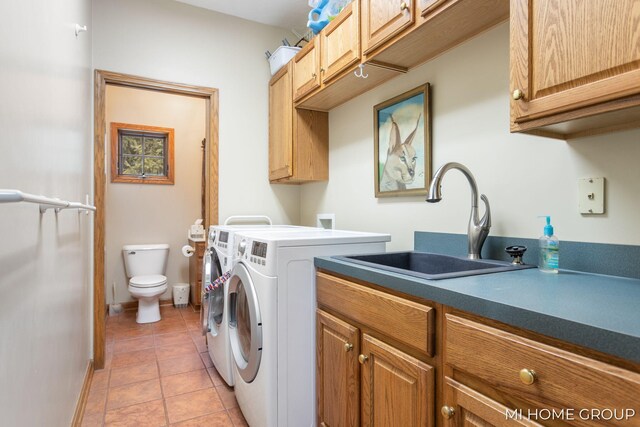 washroom with cabinets, independent washer and dryer, light tile patterned flooring, and sink