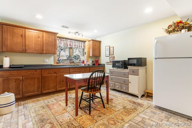 kitchen with sink and white fridge