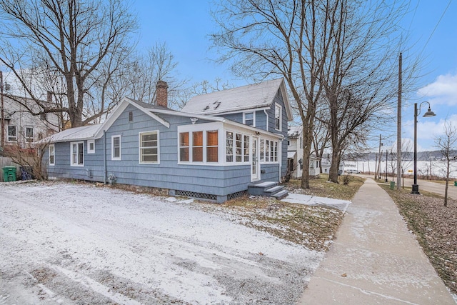 view of snowy exterior featuring a sunroom